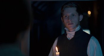 Movie still from “Jane Eyre” (2011), directed by Cary Joji Fukunaga – A young man holding a lit candle in a dark room; Close Up shot, Over the shoulder angle