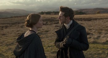 Movie still from “Jane Eyre” (2011), directed by Cary Joji Fukunaga – A man and a woman standing next to each other in a field; Medium shot, Over the shoulder angle