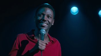 A man holding a microphone in front of a microphone stand