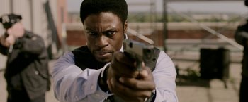 Movie still from “Jigsaw” (2017), directed by Michael Spierig – A man holding a gun in his hand; Close Up shot, Over the shoulder angle