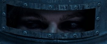 The face of a person wearing a metal helmet