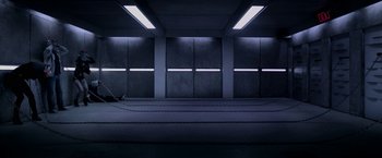 Movie still from “Jigsaw” (2017), directed by Michael Spierig – A dark room with lights on the walls and the floor; Extreme Wide shot, High angle