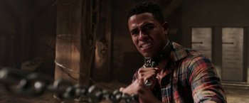 Movie still from “Jigsaw” (2017), directed by Michael Spierig – A young man holding a chain in his hand; Close Up shot, Over the shoulder angle