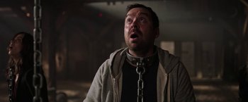 Movie still from “Jigsaw” (2017), directed by Michael Spierig – A person with a chain around his neck; Close Up shot, Low angle