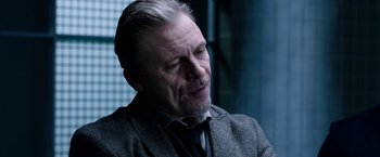 Movie still from “Jigsaw” (2017), directed by Michael Spierig – An older man in a suit and tie looking down; Close Up shot, Over the shoulder angle