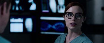Movie still from “Jigsaw” (2017), directed by Michael Spierig – A woman wearing glasses and a green shirt; Close Up shot, Over the shoulder angle