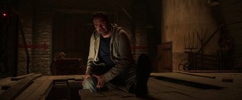 Movie still from “Jigsaw” (2017), directed by Michael Spierig – A man sitting on the ground in a dark room; Medium shot, Low angle