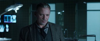 Movie still from “Jigsaw” (2017), directed by Michael Spierig – A person wearing a suit and tie; Close Up shot, Over the shoulder angle