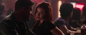 Movie still from “Jigsaw” (2017), directed by Michael Spierig – A beautiful young woman with long red hair and blue eyes standing next to a man in a black shirt; Close Up shot, Over the shoulder angle