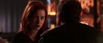 Movie still from “Jigsaw” (2017), directed by Michael Spierig – A woman with red hair is looking at a man in a leather jacket; Close Up shot, Over the shoulder angle