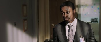 Movie still from “Jigsaw” (2017), directed by Michael Spierig – A man wearing a suit and tie in front of a window; Close Up shot, Over the shoulder angle