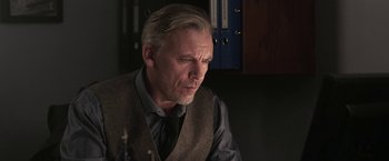 Movie still from “Jigsaw” (2017), directed by Michael Spierig – An older man wearing a vest and a tie; Close Up shot, Over the shoulder angle