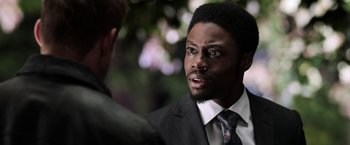 Movie still from “Jigsaw” (2017), directed by Michael Spierig – A man in a business suit talking to another man in a business suit; Close Up shot, Over the shoulder angle