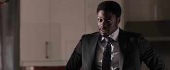 Movie still from “Jigsaw” (2017), directed by Michael Spierig – A man in a suit and tie looking at the camera; Close Up shot, Over the shoulder angle