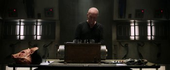 Movie still from “Jigsaw” (2017), directed by Michael Spierig – A man standing in front of an electric device; Medium shot, Low angle