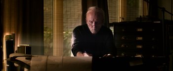 Movie still from “Jigsaw” (2017), directed by Michael Spierig – An older man writing on a piece of paper; Medium shot, Low angle