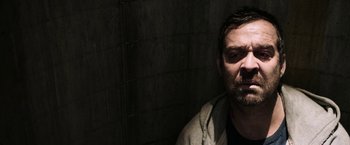 Movie still from “Jigsaw” (2017), directed by Michael Spierig – A person leaning against a wall; Close Up shot, Over the shoulder angle