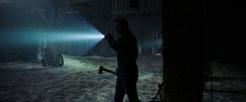 A man holding an axe in a dark room
