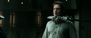 Movie still from “Jigsaw” (2017), directed by Michael Spierig – A man holding a pair of robotic arms over his head; Close Up shot, Low angle