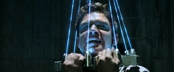 Movie still from “Jigsaw” (2017), directed by Michael Spierig – A man with blue eyes holding a bunch of wires; Close Up shot, Low angle