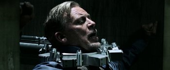 Movie still from “Jigsaw” (2017), directed by Michael Spierig – A person wearing a neck brace; Close Up shot, Over the shoulder angle