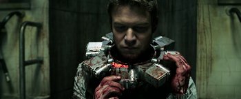 Movie still from “Jigsaw” (2017), directed by Michael Spierig – A man with blood all over his face and chest; Close Up shot, Low angle