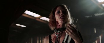 Movie still from “Jigsaw” (2017), directed by Michael Spierig – A woman in chains with blood all over her face; Close Up shot, Low angle