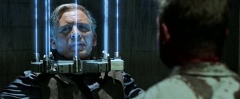 Movie still from “Jigsaw” (2017), directed by Michael Spierig – A man is reflected in the mirror of a mirror; Close Up shot, Over the shoulder angle