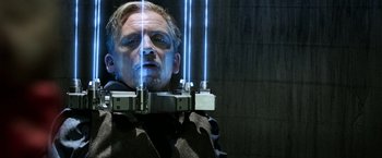 Movie still from “Jigsaw” (2017), directed by Michael Spierig – A man in a black jacket is looking into a mirror; Close Up shot, Low angle