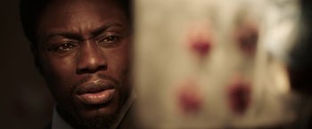 Movie still from “Jigsaw” (2017), directed by Michael Spierig – A person's face in front of a mirror; Extreme Close Up shot, Over the shoulder angle