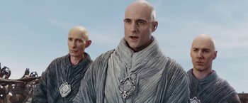 Movie still from “John Carter” (2012), directed by Andrew Stanton – A man with bald head wearing a gray robe; Medium shot, Low angle