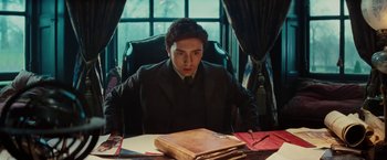 Movie still from “John Carter” (2012), directed by Andrew Stanton – A man sitting at a table in front of papers; Medium shot, Low angle