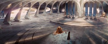 Movie still from “John Carter” (2012), directed by Andrew Stanton – A woman in a long brown dress sitting in an empty room; Extreme Wide shot, High angle