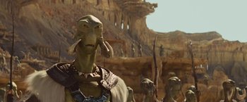 Movie still from “John Carter” (2012), directed by Andrew Stanton – A group of people standing in front of a rock formation; Close Up shot, Over the shoulder angle