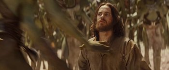 Movie still from “John Carter” (2012), directed by Andrew Stanton – A man with long brown hair and a long beard; Medium shot, Low angle