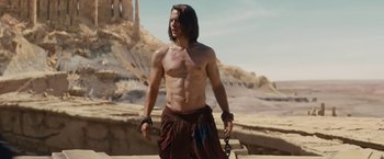 Movie still from “John Carter” (2012), directed by Andrew Stanton – A shirtless man standing on top of a hill; Medium shot, Low angle