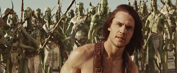 Movie still from “John Carter” (2012), directed by Andrew Stanton – A group of people in a field with a man with a beard; Medium shot, Over the shoulder angle
