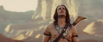Movie still from “John Carter” (2012), directed by Andrew Stanton – A man with long brown hair wearing a leather harness; Medium shot, Low angle