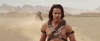 Movie still from “John Carter” (2012), directed by Andrew Stanton – A man with a sword in the desert; Medium shot, Over the shoulder angle