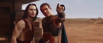 Movie still from “John Carter” (2012), directed by Andrew Stanton – A man pointing to the sky while standing next to another man; Medium shot, Over the shoulder angle