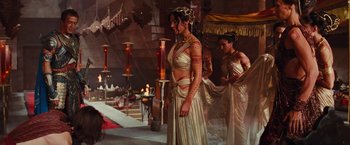 Movie still from “John Carter” (2012), directed by Andrew Stanton – A woman in a gold dress standing next to another woman in a gold dress; Wide shot, Over the shoulder angle