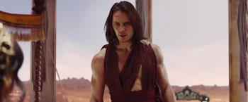 Movie still from “John Carter” (2012), directed by Andrew Stanton – A man with long brown hair wearing a red shirt; Medium shot, Low angle