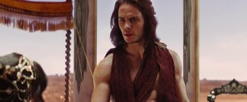 Movie still from “John Carter” (2012), directed by Andrew Stanton – A man with long hair is wearing a red shirt; Medium shot, Low angle