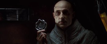 Movie still from “John Carter” (2012), directed by Andrew Stanton – A bald man holding something in his hand; Close Up shot, Low angle