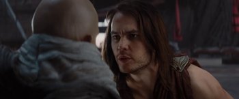 Movie still from “John Carter” (2012), directed by Andrew Stanton – A man with long brown hair is looking at a bald man; Close Up shot, Over the shoulder angle