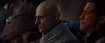 Movie still from “John Carter” (2012), directed by Andrew Stanton – A man with bald head and ear buds in his ears; Close Up shot, Over the shoulder angle
