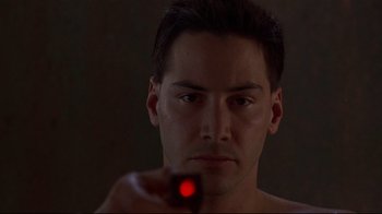 Movie still from “Johnny Mnemonic” (1995), directed by Robert Longo – A man is looking into a mirror with a red light in his eye; Close Up shot, Low angle