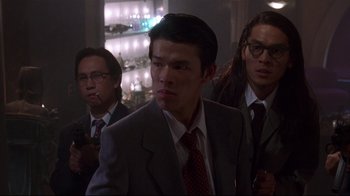 Movie still from “Johnny Mnemonic” (1995), directed by Robert Longo – A group of men standing next to each other in a room; Medium shot, Low angle