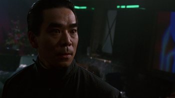 Movie still from “Johnny Mnemonic” (1995), directed by Robert Longo – A person in a dark room; Close Up shot, Low angle