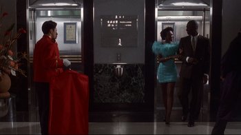 Movie still from “Johnny Mnemonic” (1995), directed by Robert Longo – A group of people standing in front of a urinal; Wide shot, Low angle
